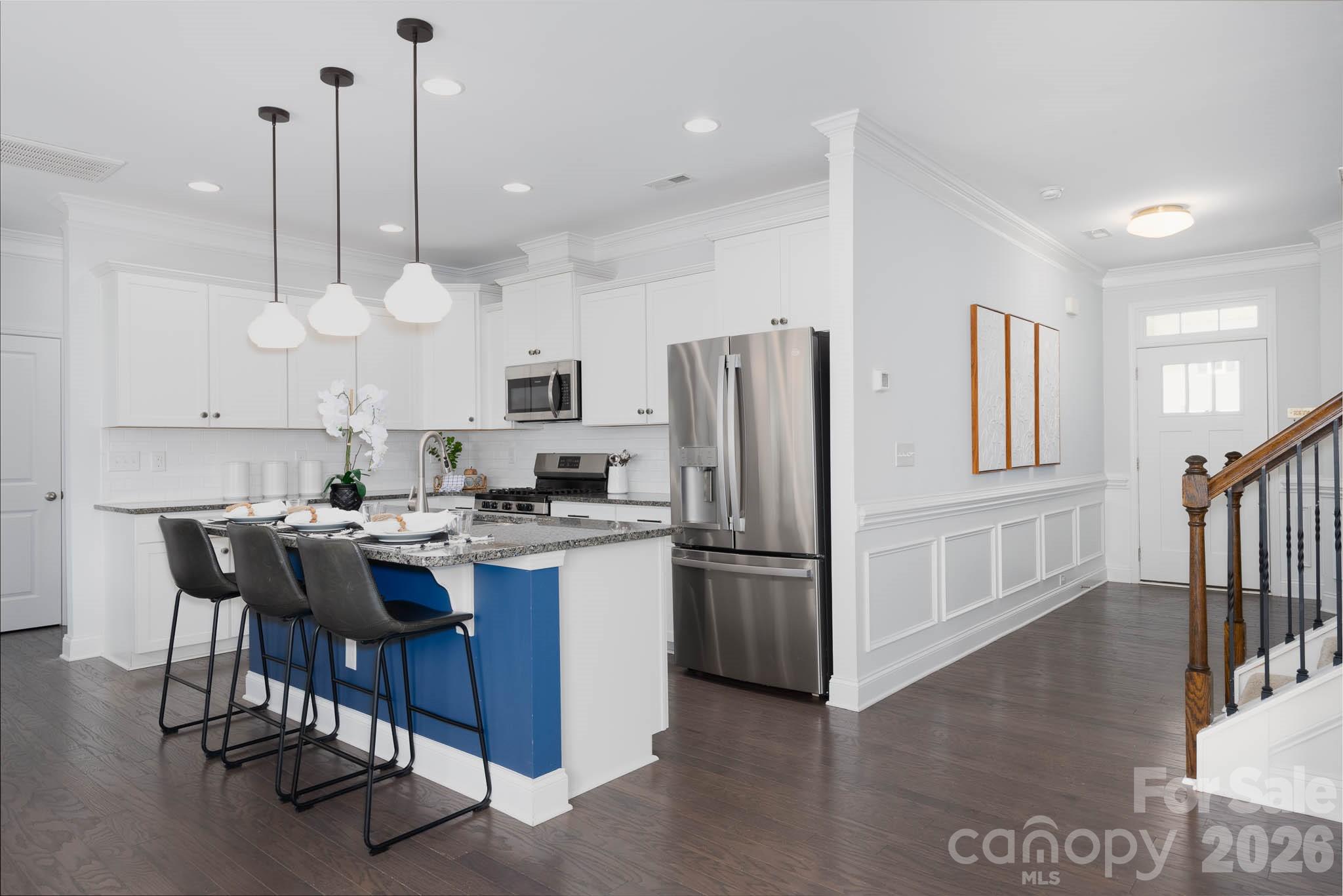 108 Chance Road Mooresville, NC 28115 - Photo 10 of 37 a kitchen with stainless steel appliances kitchen island granite countertop a table chairs and a refrigerator