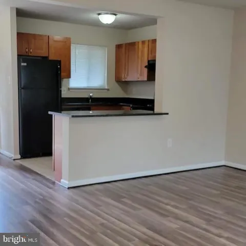a kitchen with wooden floor and black appliances
