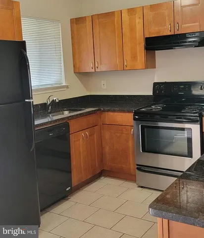 a kitchen with granite countertop a sink and a stove top oven