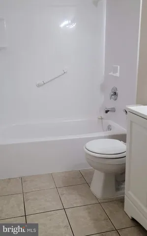 a white toilet sitting next to a bath tub