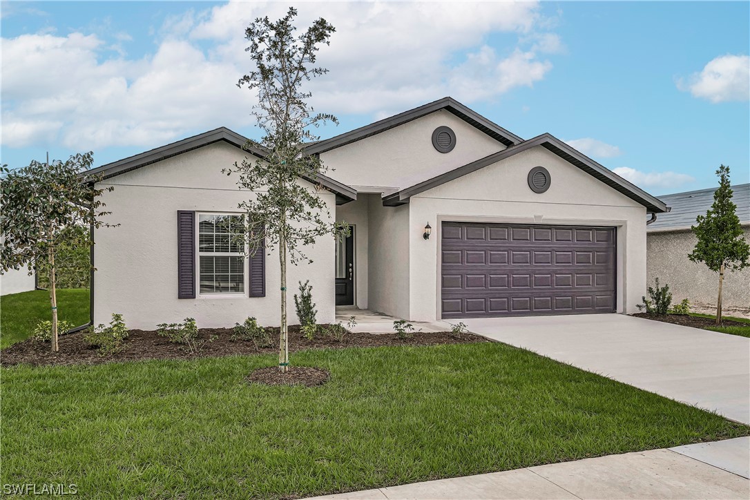 1344 Lincoln Court Immokalee, FL 34142 - Photo 2 of 21 a front view of a house with a yard and garage
