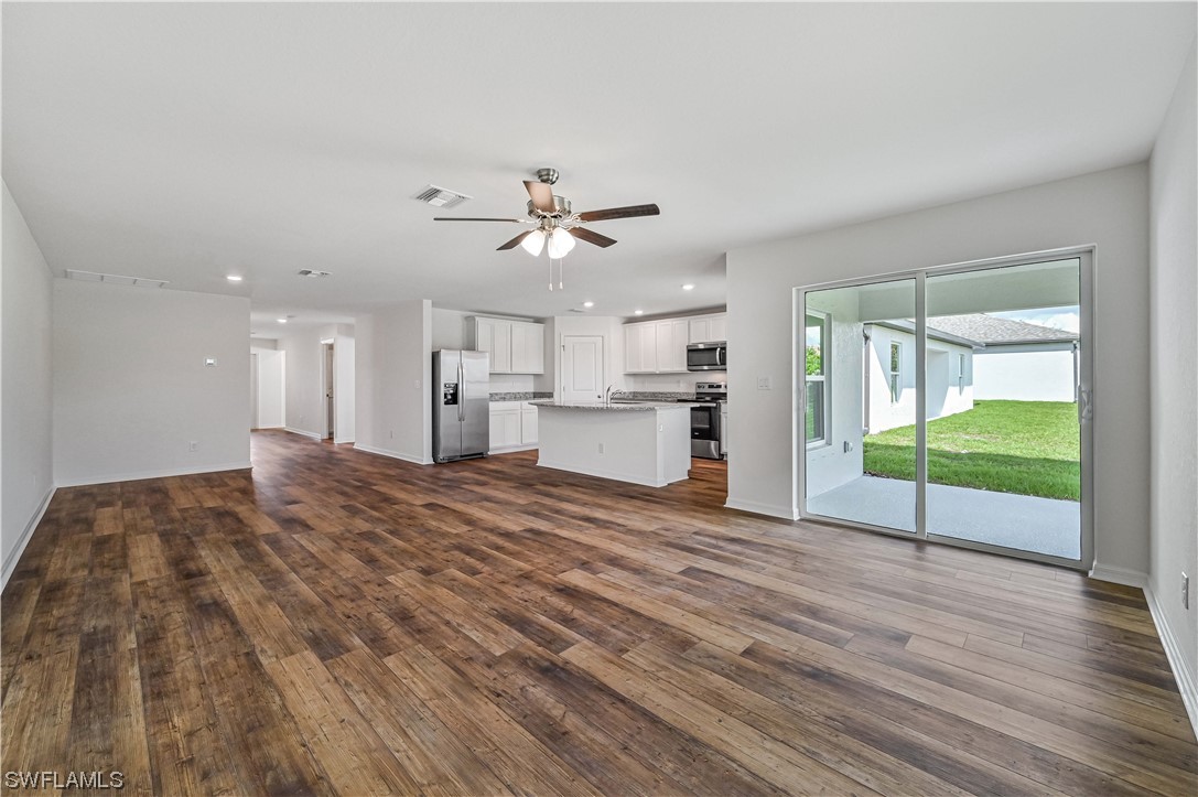 1344 Lincoln Court Immokalee, FL 34142 - Photo 5 of 21 a view of a livingroom with a fireplace a ceiling fan and wooden floor