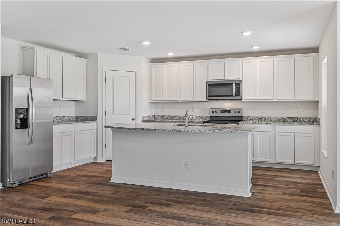 1344 Lincoln Court Immokalee, FL 34142 - Photo 7 of 21 a kitchen with granite countertop white cabinets and stainless steel appliances