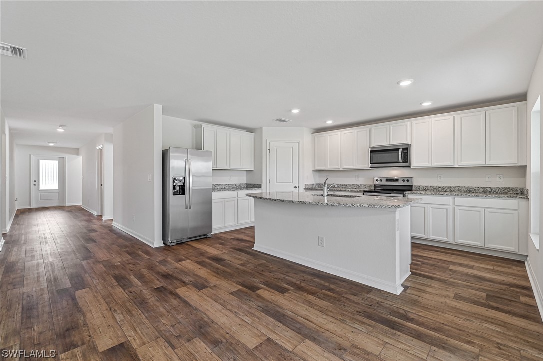 1344 Lincoln Court Immokalee, FL 34142 - Photo 8 of 21 a kitchen with a refrigerator and white cabinets