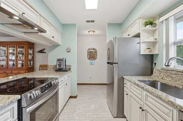 a kitchen with stainless steel appliances granite countertop a stove and a refrigerator