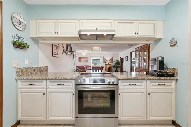a kitchen with granite countertop white cabinets and white appliances