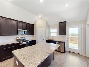 3421 Buster Way Corinth, TX 76210 - Photo 2 of 11 a kitchen with stainless steel appliances granite countertop wooden cabinets a stove top oven a sink and dishwasher