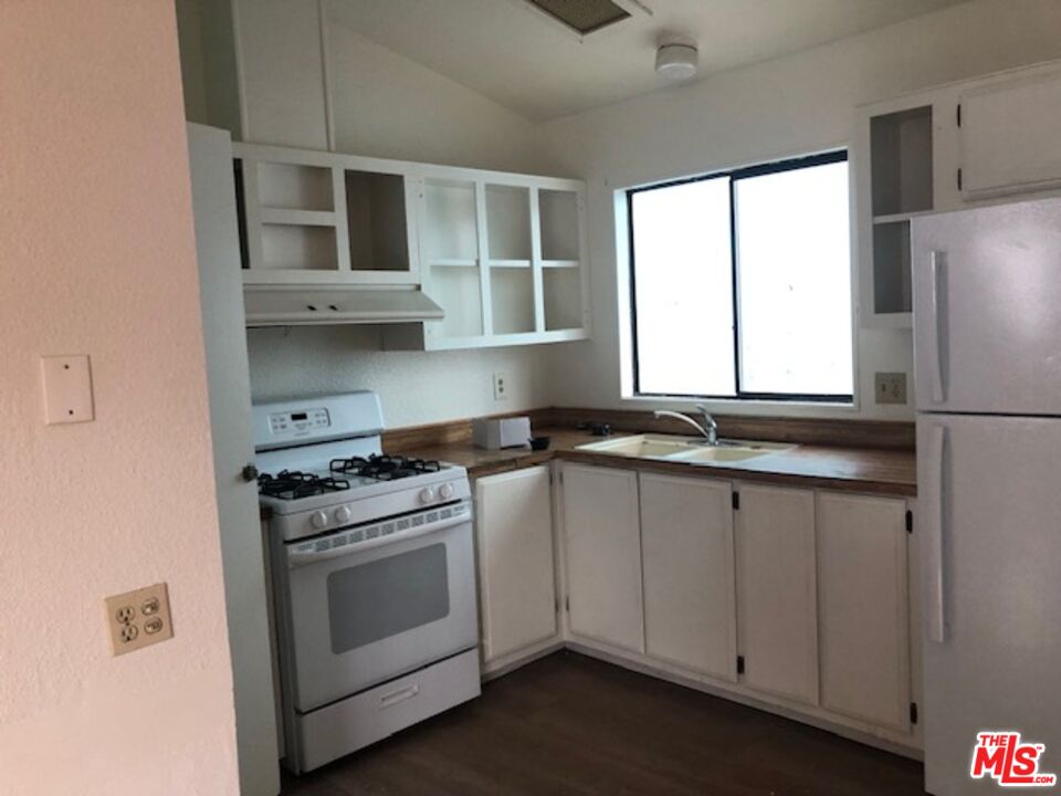 355 Center Street Oakland, CA 94607 - Photo 2 of 10 a kitchen with stainless steel appliances white cabinets and a window