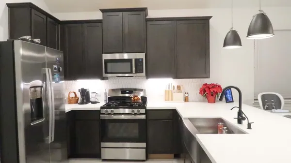 a kitchen with stainless steel appliances a refrigerator sink and microwave