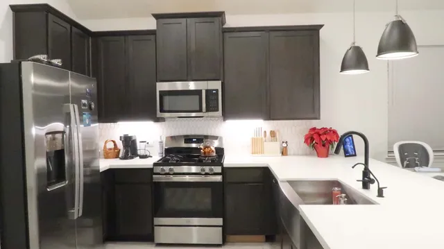 a kitchen with stainless steel appliances a refrigerator sink and microwave