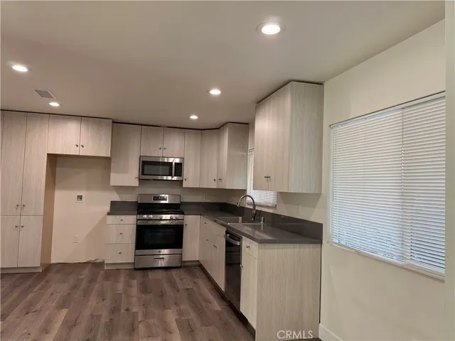 a kitchen with granite countertop white cabinets and stainless steel appliances