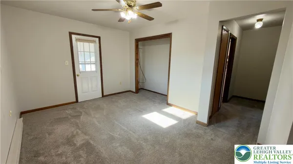 an empty room with closet and a chandelier fan