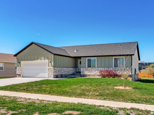 75 North 100th Street West Fillmore, UT 84631 - Photo 1 of 62 Ranch-style house featuring board and batten siding, driveway, an attached garage, stone siding, and a residential view