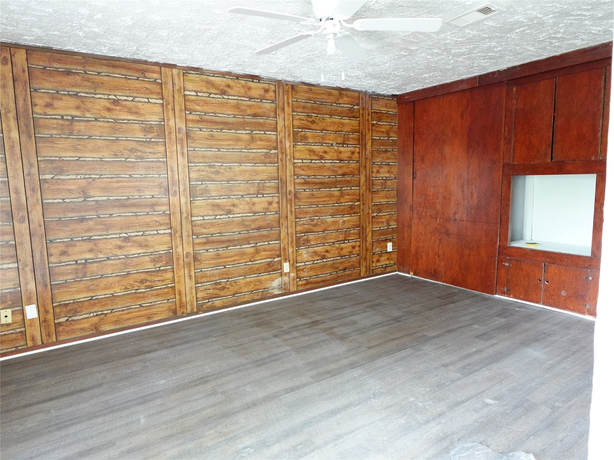 8022 Woodlyn Road Houston, TX 77028 - Photo 2 of 7 an empty room with wooden floor fan and windows