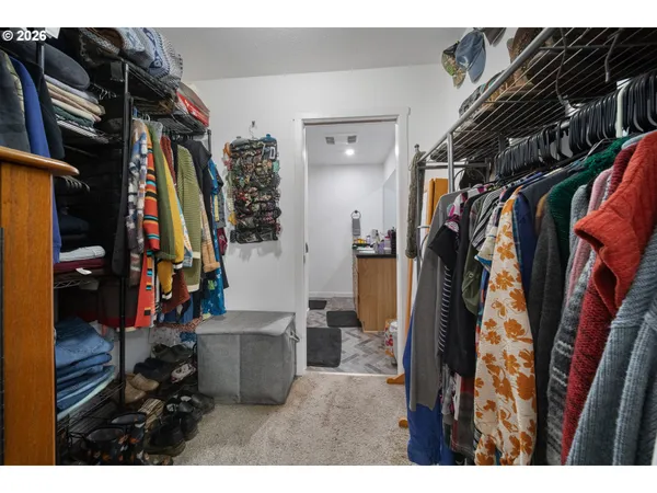 a view of walk in closet with clothes and shoes