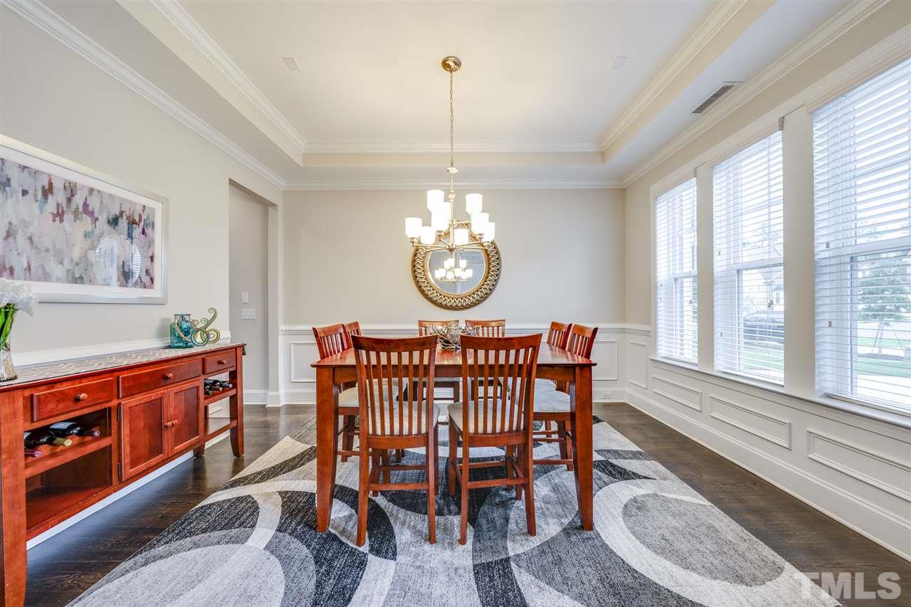7504 Pinaster Place Raleigh, NC 27613 - Photo 2 of 30 a view of a dining room with furniture a chandelier and wooden floor