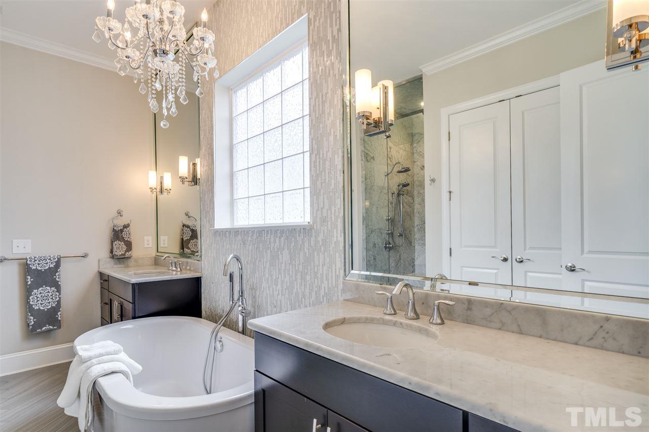7504 Pinaster Place Raleigh, NC 27613 - Photo 15 of 30 a bathroom with a tub sink and mirror