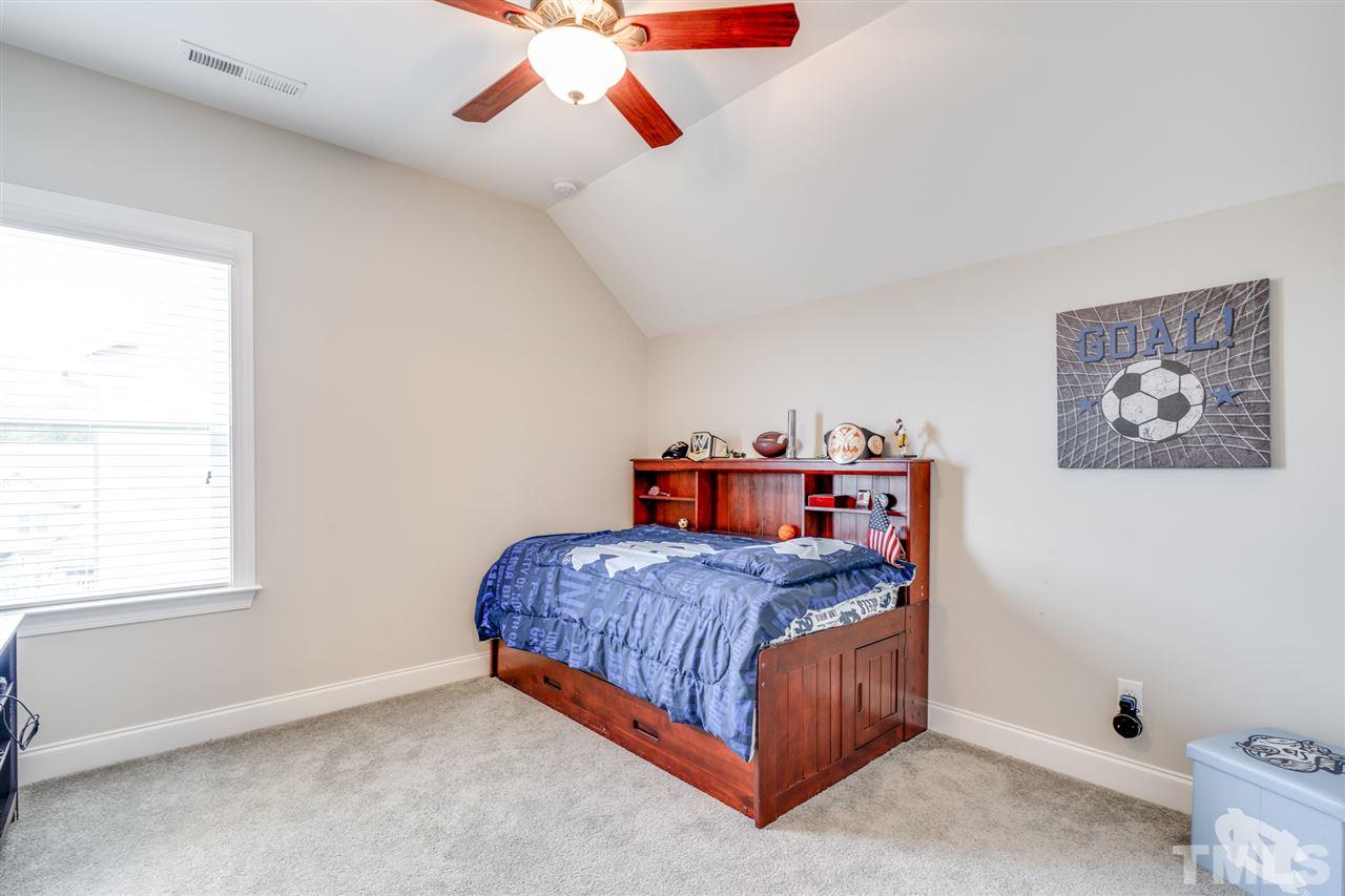 7504 Pinaster Place Raleigh, NC 27613 - Photo 18 of 30 a bedroom with a bed and window