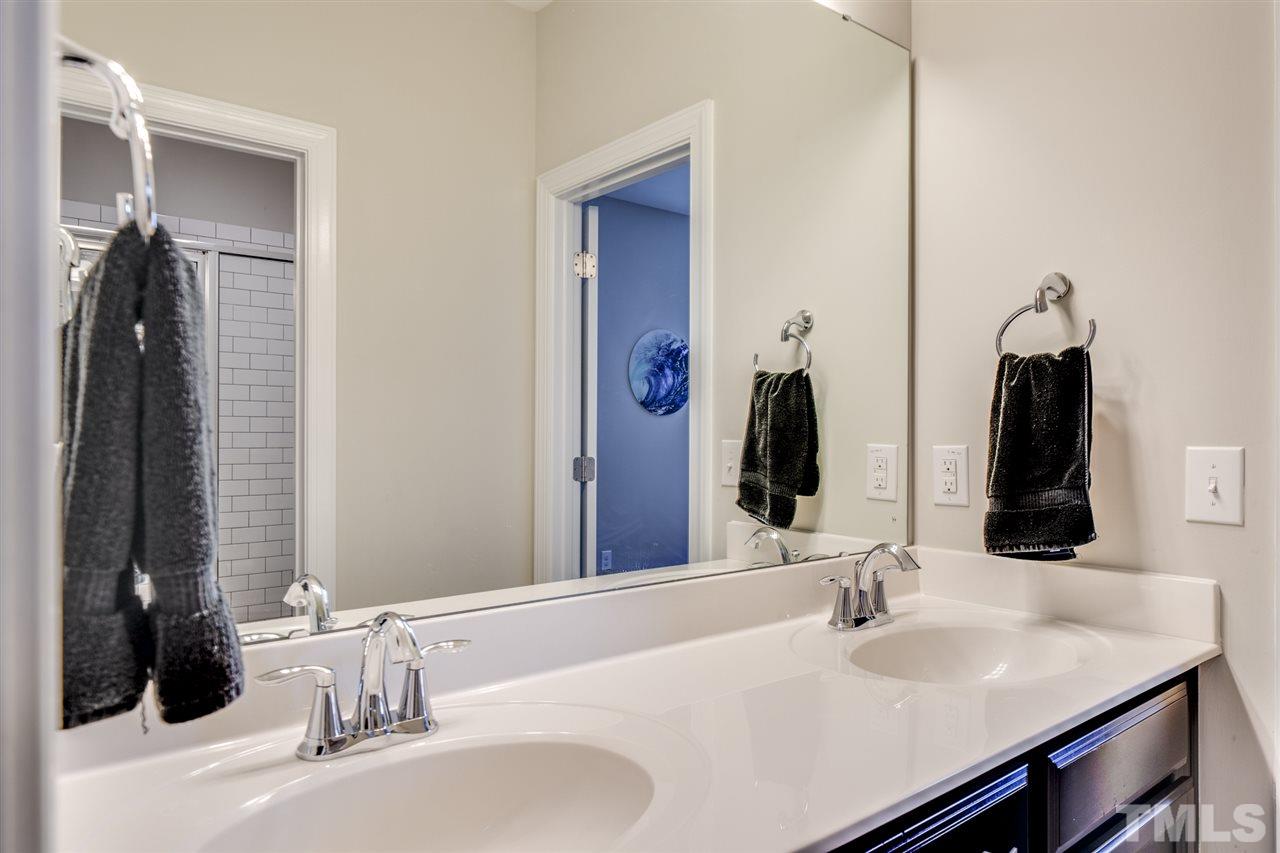 7504 Pinaster Place Raleigh, NC 27613 - Photo 19 of 30 a bathroom with double vanity sinks and a mirror