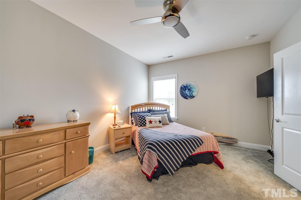 7504 Pinaster Place Raleigh, NC 27613 - Photo 22 of 30 a bedroom with a bed and a tv on the dresser