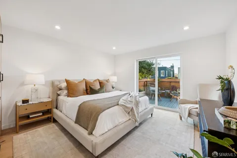 a spacious bedroom with a bed and a mirror