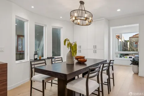 a kitchen with stainless steel appliances granite countertop a table chairs sink and cabinets