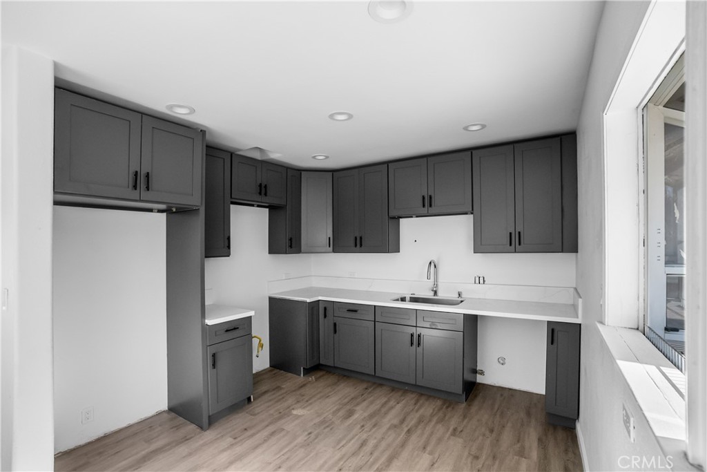 20554 Valerio Street Winnetka, CA 91306 - Photo 6 of 12 a kitchen with stainless steel appliances a sink cabinets and wooden floor