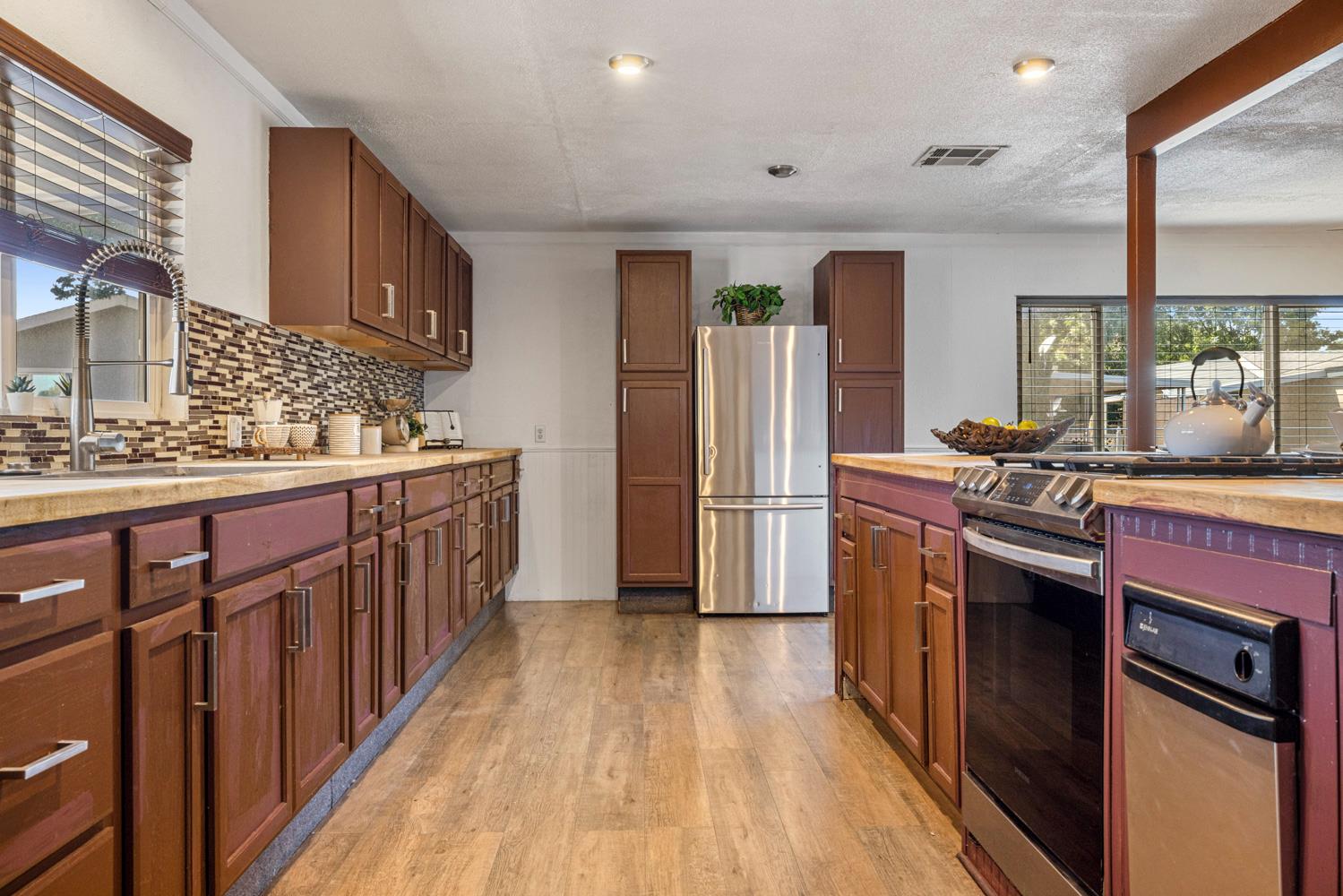 2621 Prescott Road, Unit 79 Modesto, CA 95350 - Photo 25 of 41 a kitchen with stainless steel appliances a stove top oven a sink dishwasher and a refrigerator