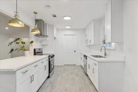 a kitchen with kitchen island granite countertop a sink a counter space and cabinets