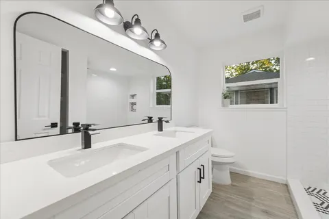 a bathroom with a double vanity sink and a mirror