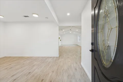 an empty room with wooden floor and mirror