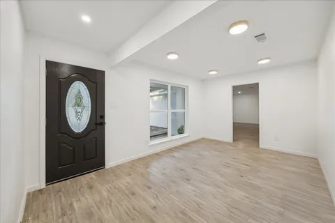 an empty room with mirror and a window