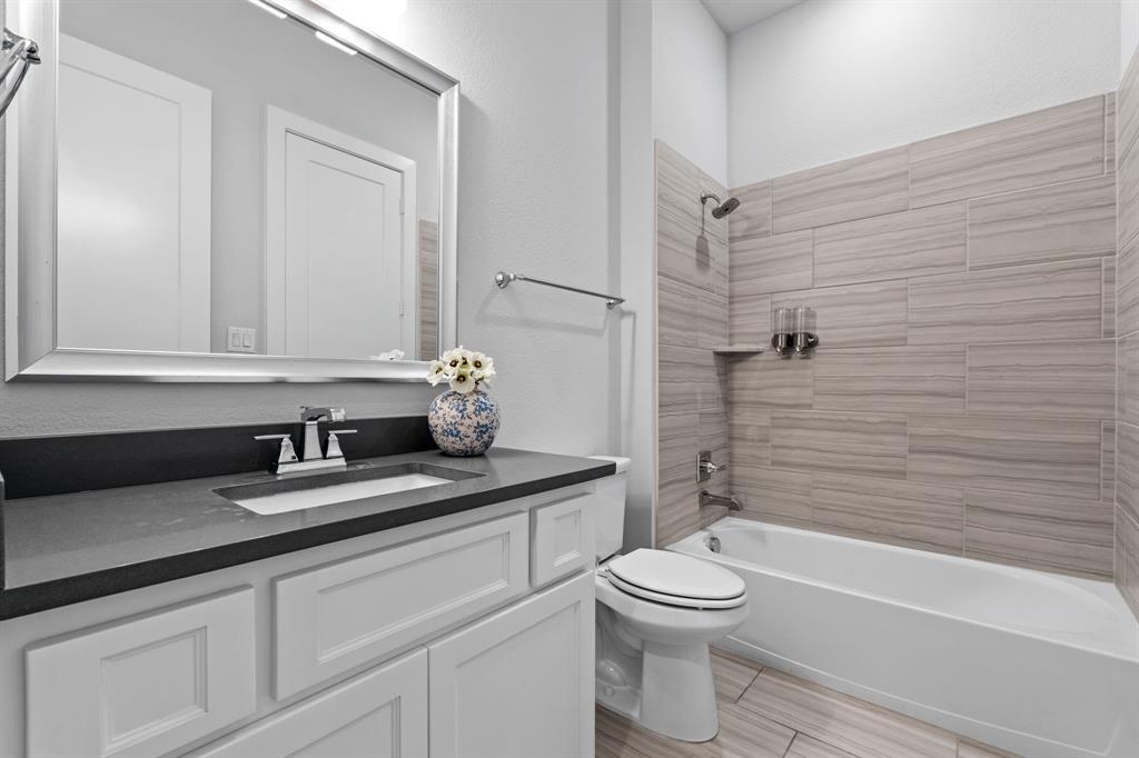4003 Marble Hill Road Frisco, TX 75034 - Photo 25 of 40 a bathroom with a granite countertop toilet sink and mirror