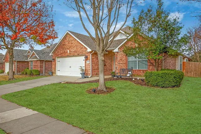 a view of a house with backyard and tree