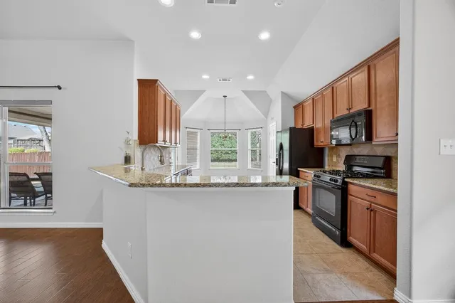 a kitchen with stainless steel appliances granite countertop a sink stove and refrigerator