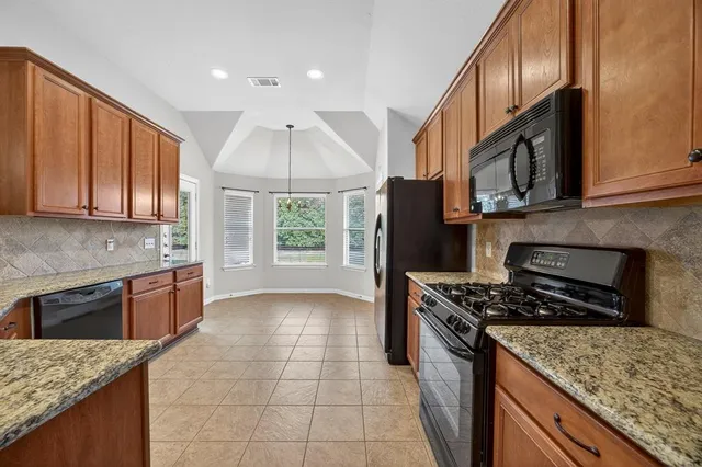 a kitchen with granite countertop cabinets stainless steel appliances and a counter space