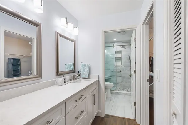 a bathroom with a sink a toilet and shower