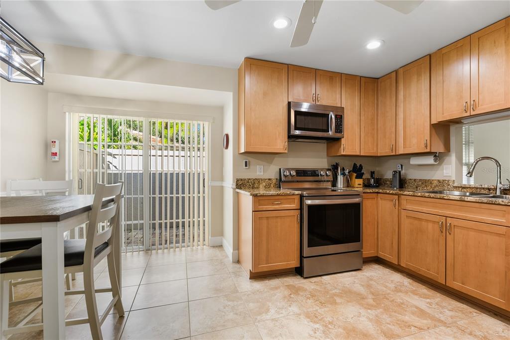 4016 Oakley Greene, Unit 40 Sarasota, FL 34235 - Photo 17 of 51 a kitchen with granite countertop a stove top oven microwave and cabinets