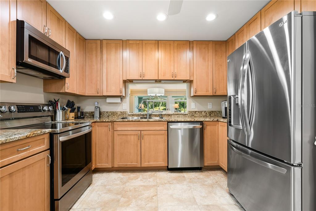 4016 Oakley Greene, Unit 40 Sarasota, FL 34235 - Photo 19 of 51 a kitchen with stainless steel appliances granite countertop a refrigerator stove a sink dishwasher and microwave