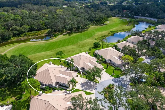 an aerial view of a house with a garden and lake view