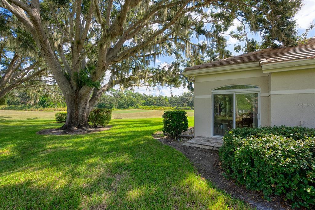 4016 Oakley Greene, Unit 40 Sarasota, FL 34235 - Photo 30 of 51 a view of a house with a big yard plants and large trees
