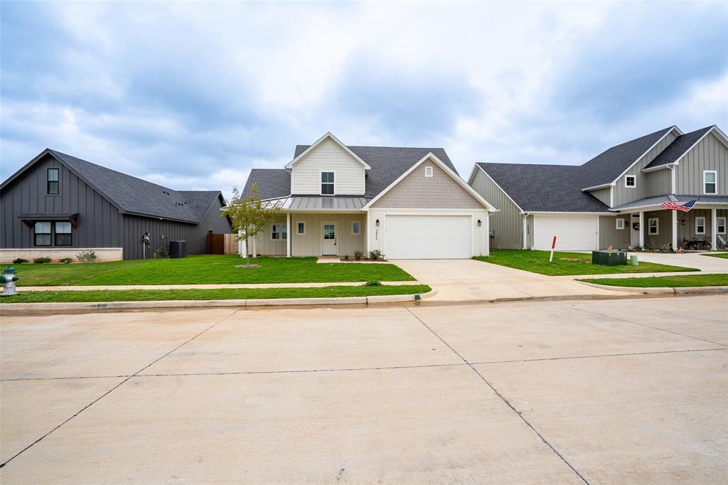 2044 Salina Circle Granbury, TX 76048 - Photo 3 of 38 a front view of a house with a garden and yard