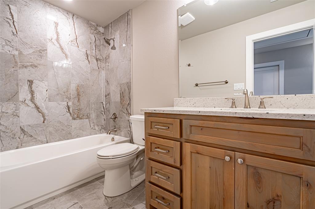 2044 Salina Circle Granbury, TX 76048 - Photo 32 of 38 a bathroom with a granite countertop sink toilet and shower