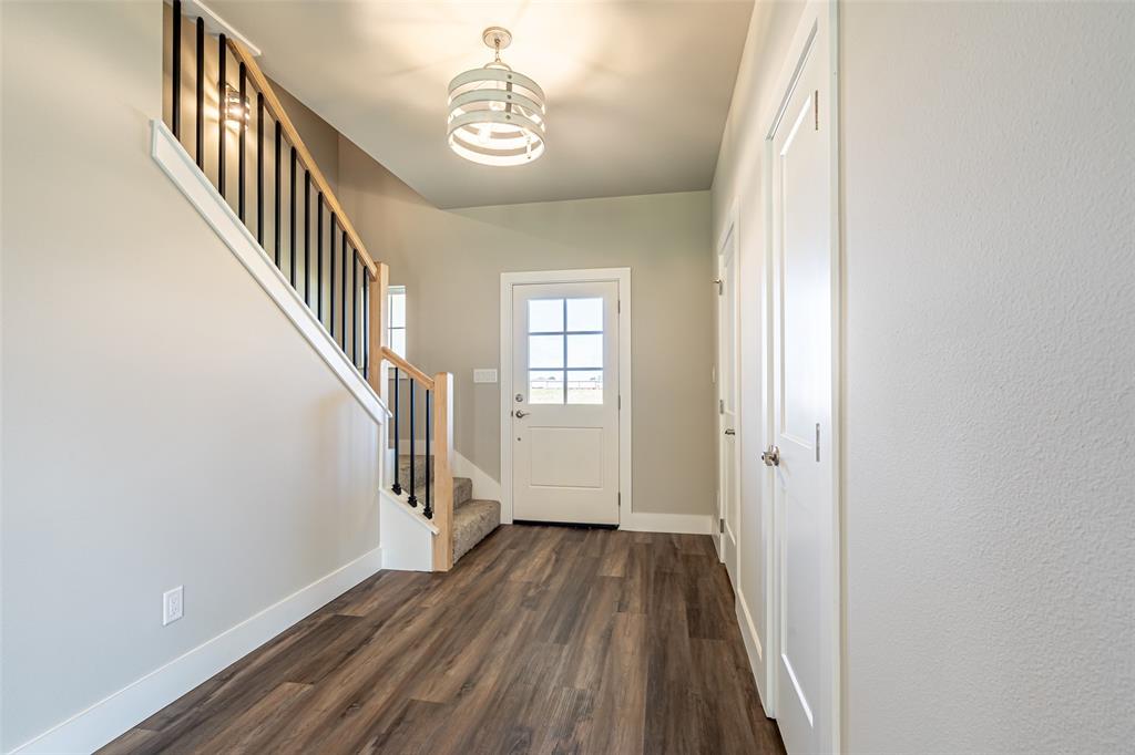 2044 Salina Circle Granbury, TX 76048 - Photo 4 of 38 a view of a hallway with wooden floor and staircase