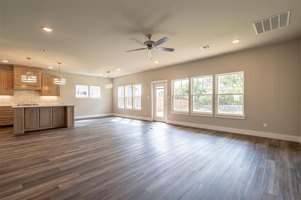2044 Salina Circle Granbury, TX 76048 - Photo 5 of 38 a view of an empty room with wooden floor and a window