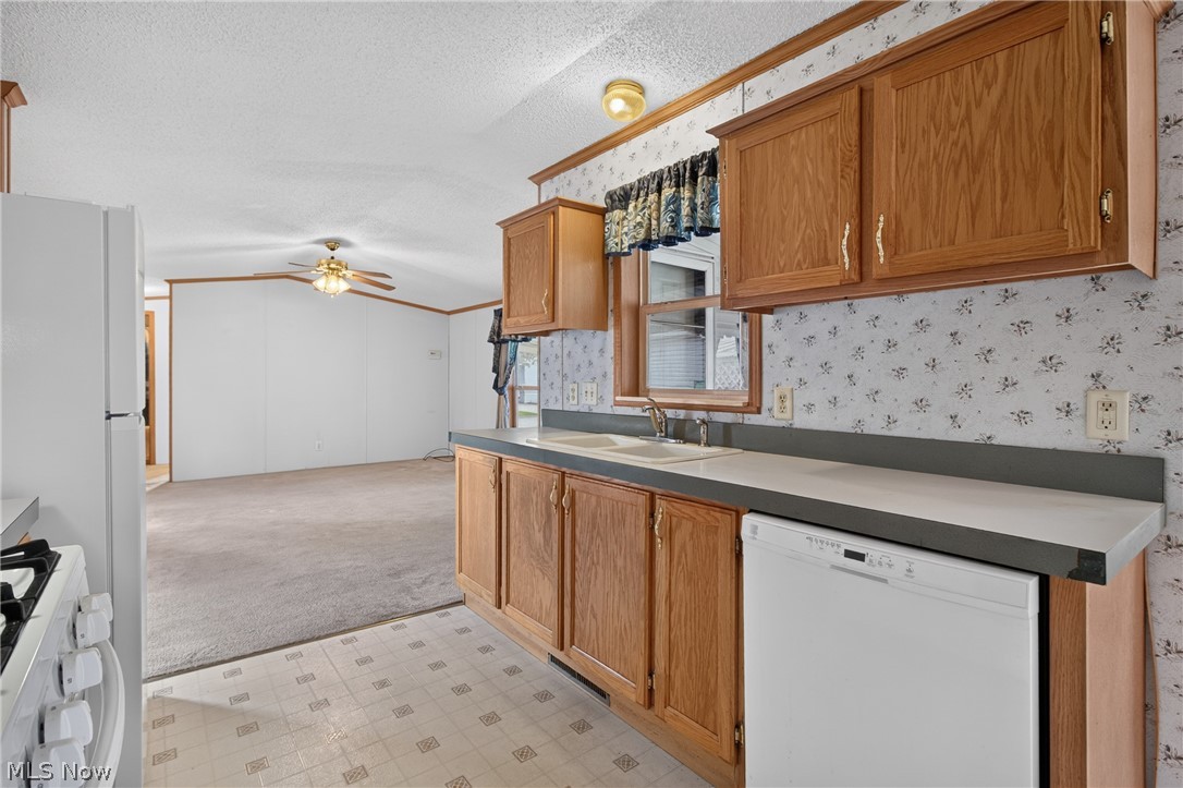 35157 Center Ridge Road, Unit 153 North Ridgeville, OH 44039 - Photo 16 of 35 Kitchen featuring wood cabinetry, integrated sink, and white dishwasher