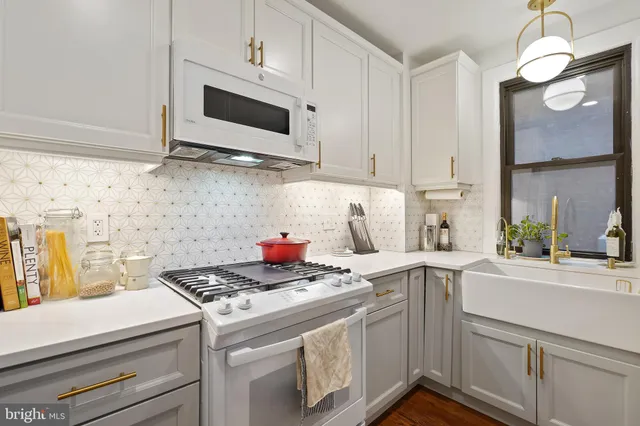 a kitchen with stainless steel appliances granite countertop a sink a stove and a microwave