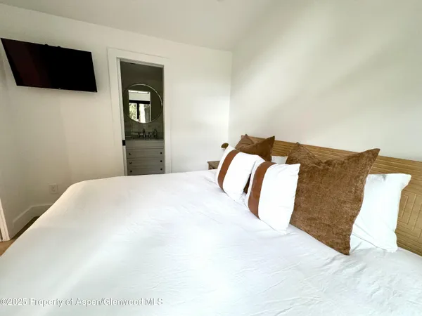 a bedroom with a bed and a flat screen tv