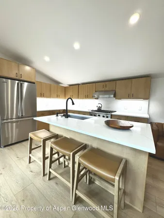 a open kitchen with stainless steel appliances granite countertop a sink refrigerator and cabinets