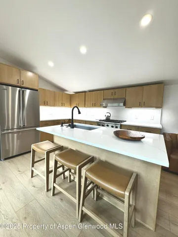 a open kitchen with stainless steel appliances granite countertop a sink refrigerator and cabinets